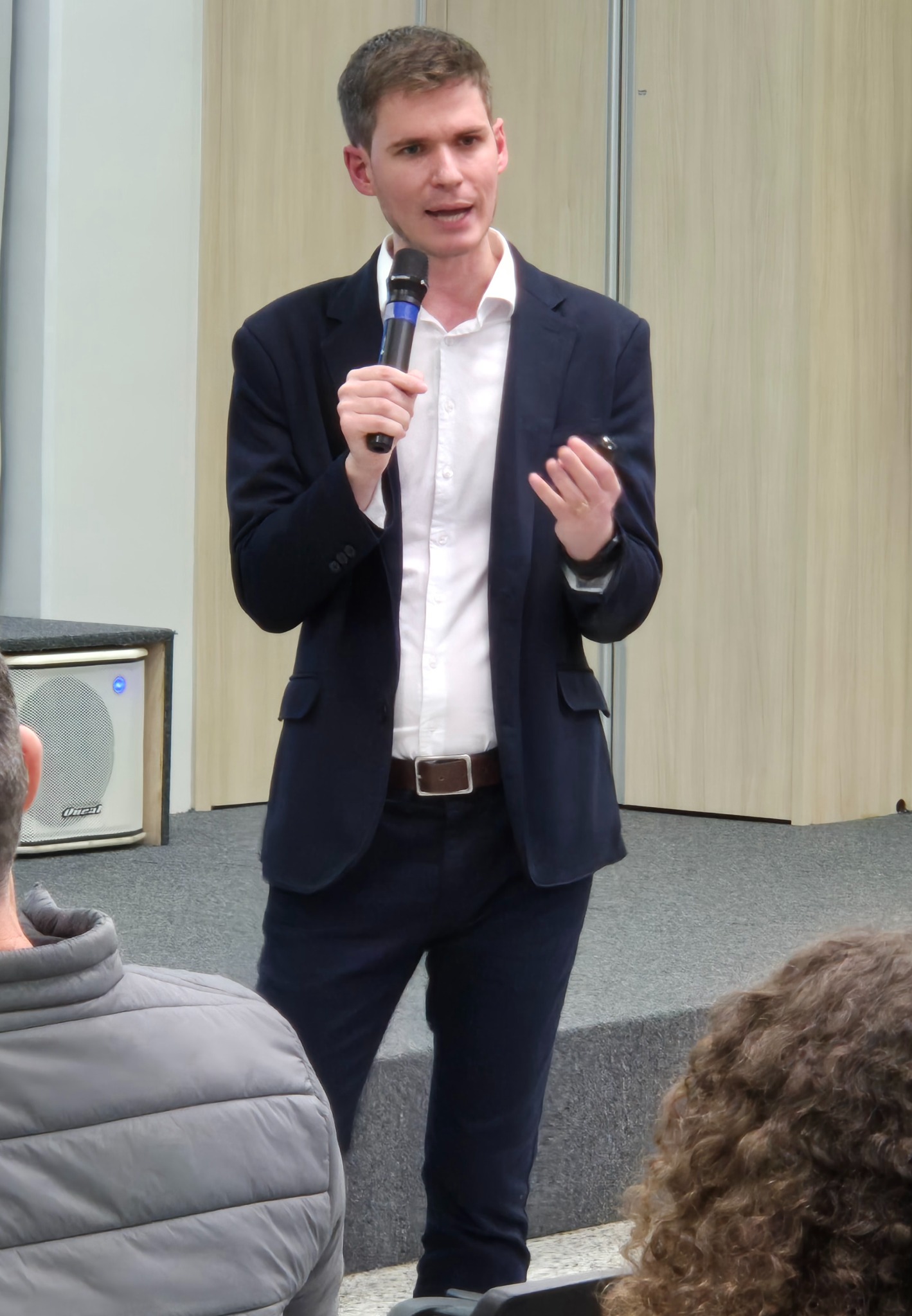 Murilo Battisti falando ao microfone durante uma palestra